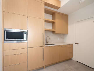 This modern kitchen boasts sleek cabinetry and a built-in microwave, perfect for contemporary living.