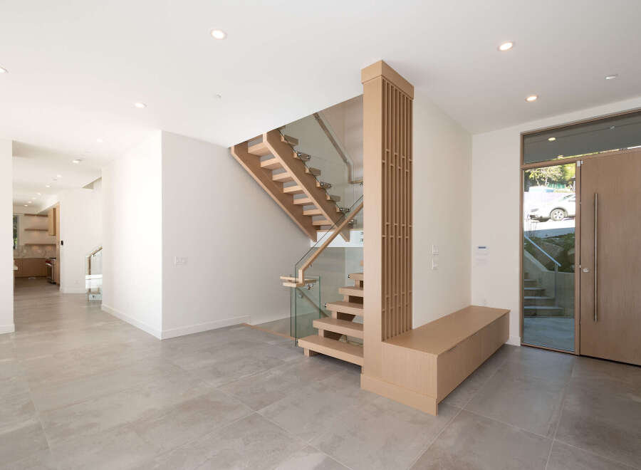 Step into modern elegance with this stunning home featuring a floating staircase and sleek glass railings.
