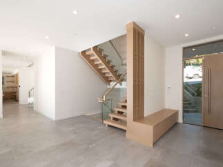 Step into modern elegance with this stunning home featuring a floating staircase and sleek glass railings.