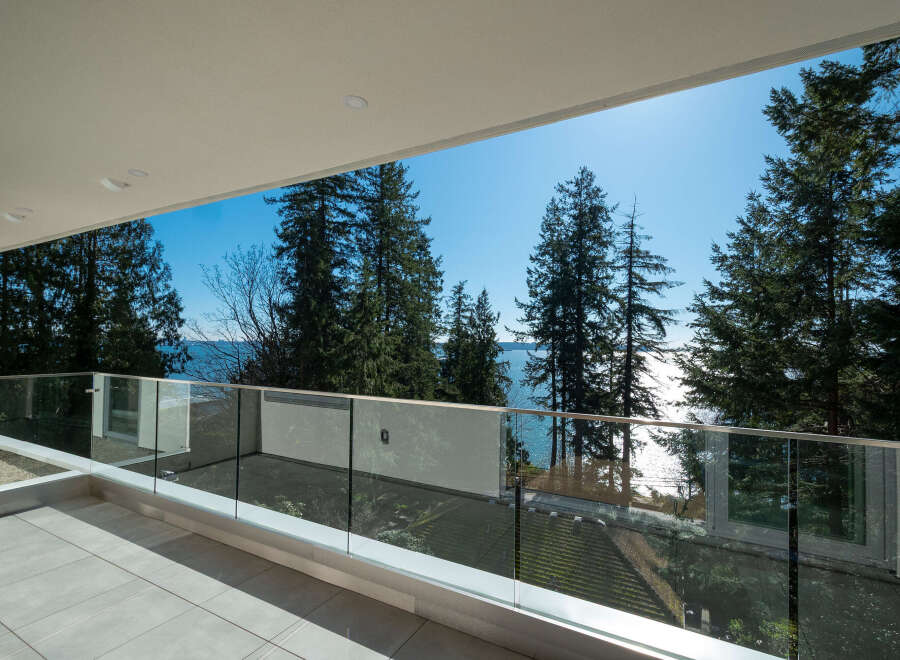 Enjoy breathtaking views from this stunning balcony overlooking the water and lush greenery.