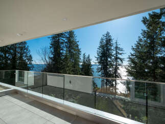 Enjoy breathtaking views from this stunning balcony overlooking the water and lush greenery.