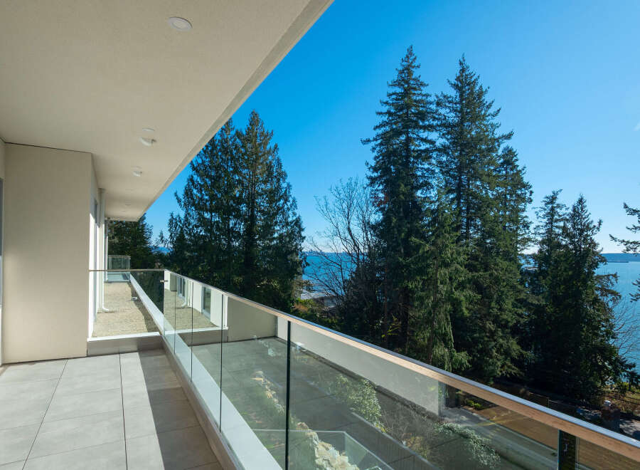 Enjoy breathtaking views from this stunning balcony overlooking the ocean and lush greenery.