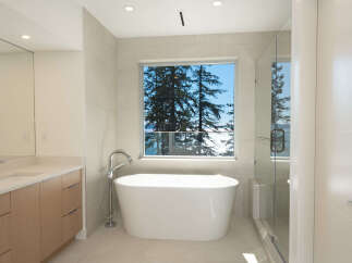 Experience luxury in this stunning bathroom featuring a modern freestanding tub and a spacious glass shower.