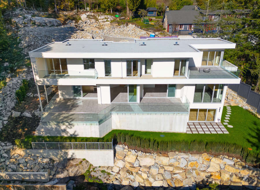 This stunning modern home offers luxurious living with its sleek design and expansive glass windows.