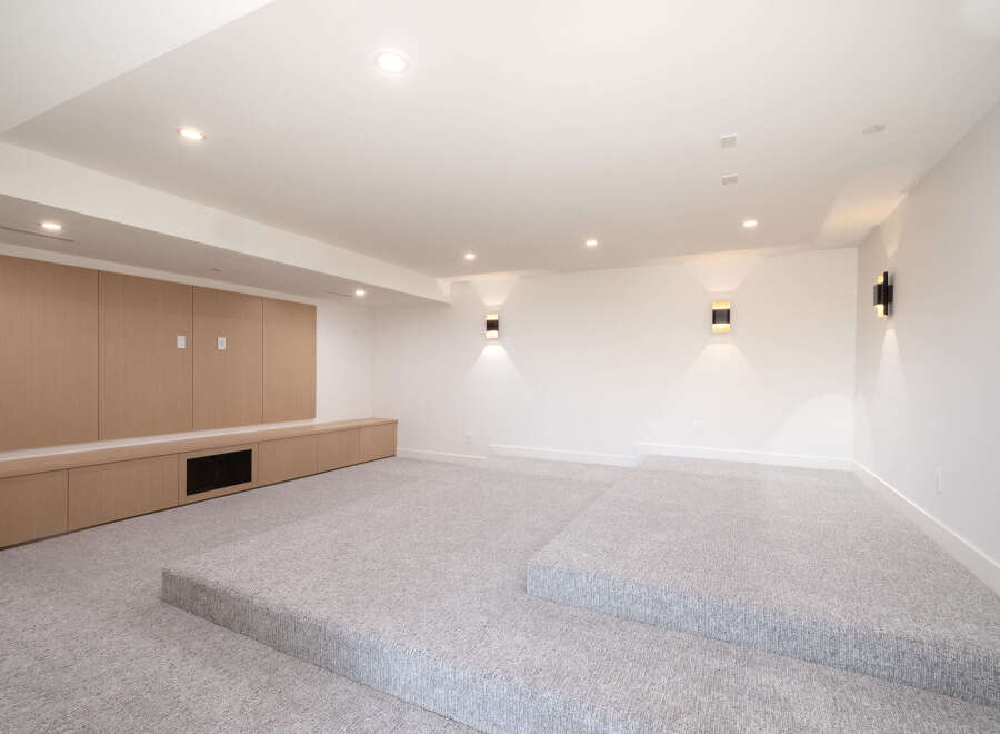 Step into luxury with this stunning home theater! Featuring a modern design, this space boasts a raised platform, perfect for optimal viewing.