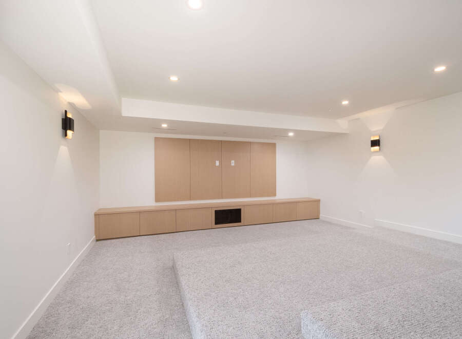 This modern living space features a built-in entertainment center with ample storage and a sleek design.