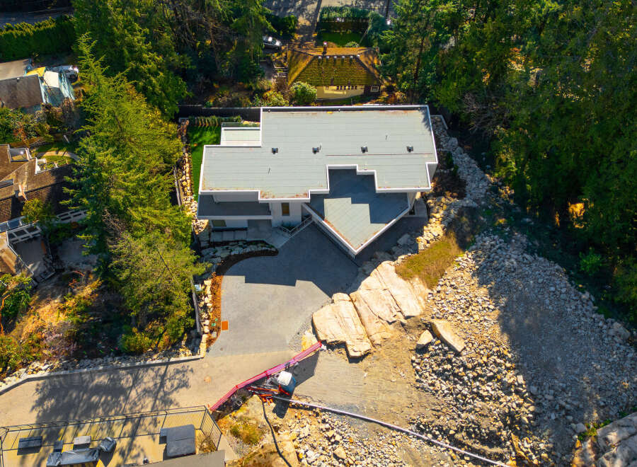 Discover a stunning modern home nestled in a serene, tree-lined setting.