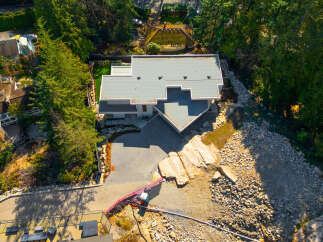 Discover a stunning modern home nestled in a serene, tree-lined setting.