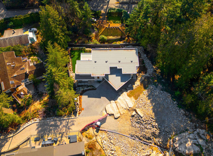 Discover a stunning modern home nestled in a serene, tree-lined setting.