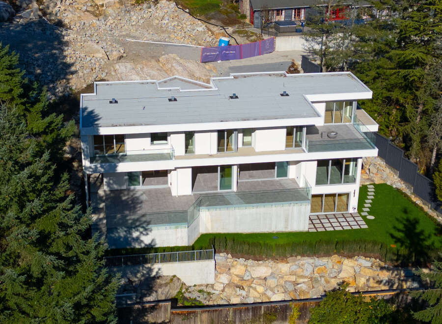 This stunning modern home boasts a sleek design with expansive windows, offering breathtaking views and abundant natural light.