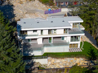 This stunning modern home boasts a sleek design with expansive windows, offering breathtaking views and abundant natural light.