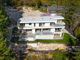 This stunning modern home offers a luxurious living experience with its sleek design and expansive views.