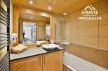 This charming bathroom features a warm, inviting ambiance with its wooden accents and neutral color palette.