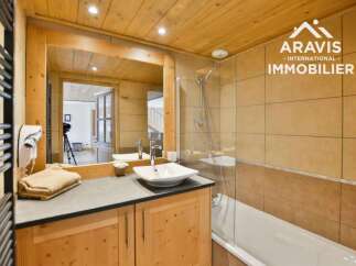 This charming bathroom features a warm, inviting ambiance with its wooden accents and neutral color palette.