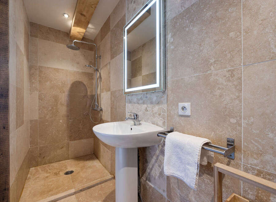 This stunning bathroom features a modern design with a walk-in shower and a pedestal sink.