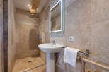 This stunning bathroom features a modern design with a walk-in shower and a pedestal sink.