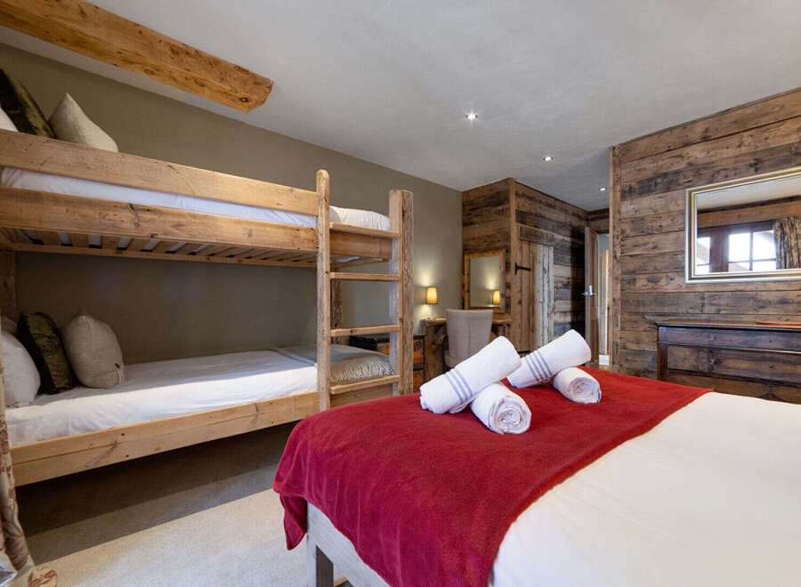 This cozy bedroom features a rustic design with wooden accents and a comfortable bunk bed, perfect for families or groups.