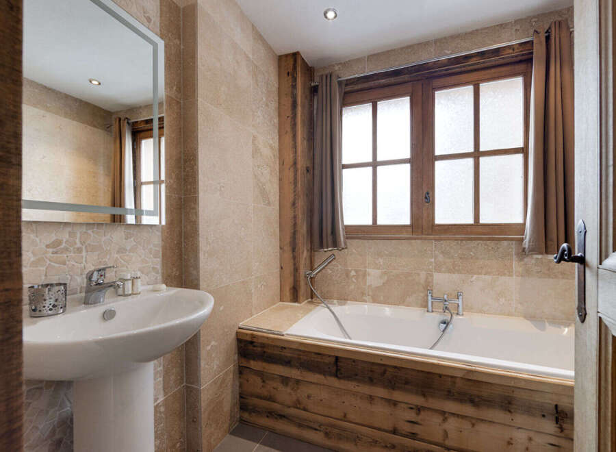 This stunning bathroom boasts a rustic charm with its wooden accents and natural stone tiles.