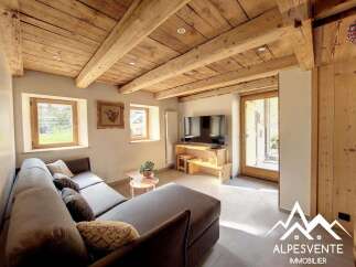 Discover the charm of this stunning property, featuring a cozy living room with a rustic wooden ceiling and a comfortable sofa.