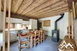 Discover the charm of this cozy kitchen, featuring a rustic wooden ceiling and a dining area perfect for gatherings.