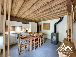 Discover the charm of this cozy kitchen, featuring a rustic wooden ceiling and a dining area perfect for gatherings.