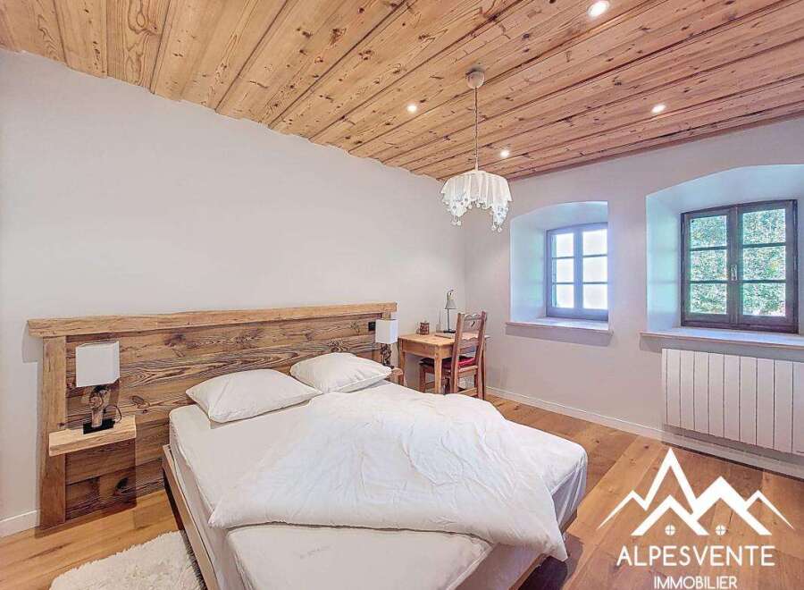 Discover the charm of this cozy bedroom featuring a rustic wooden headboard and ceiling, creating a warm and inviting atmosphere.