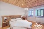 Discover the charm of this cozy bedroom featuring a rustic wooden headboard and ceiling, creating a warm and inviting atmosphere.