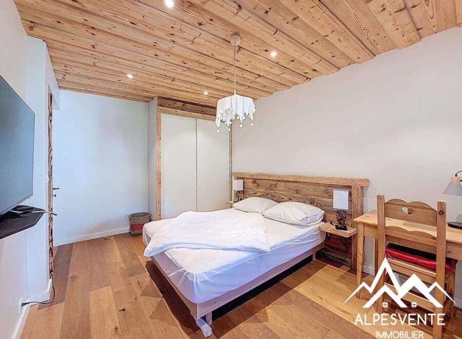 Discover a cozy bedroom retreat with a rustic wooden ceiling and flooring, creating a warm and inviting atmosphere.