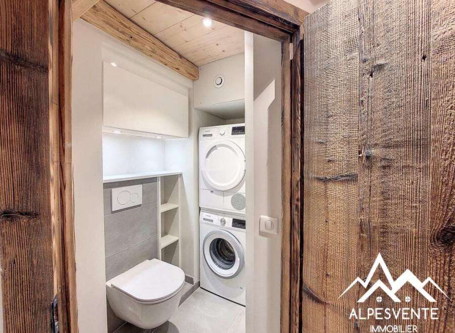 Discover this charming property featuring a modern laundry room with a stacked washer and dryer, perfect for efficient living.