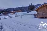 Discover a charming chalet nestled in a snowy mountain landscape, perfect for a winter getaway.