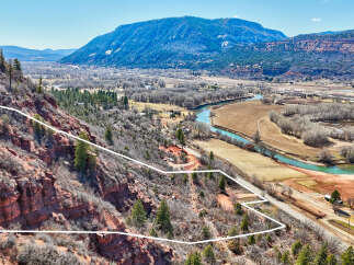 Discover a stunning piece of land with breathtaking views of the surrounding mountains and a serene river.