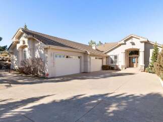 Discover luxury living in this stunning property! This home boasts a spacious driveway leading to a three-car garage, perfect for families or car enthusiasts.
