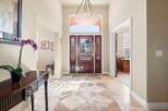 Step into luxury with this stunning entryway! The grand entrance features a beautiful wooden door, elegant marble flooring, and a stylish chandelier.