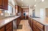 This stunning kitchen boasts rich, wooden cabinetry and elegant granite countertops, creating a warm and inviting atmosphere.