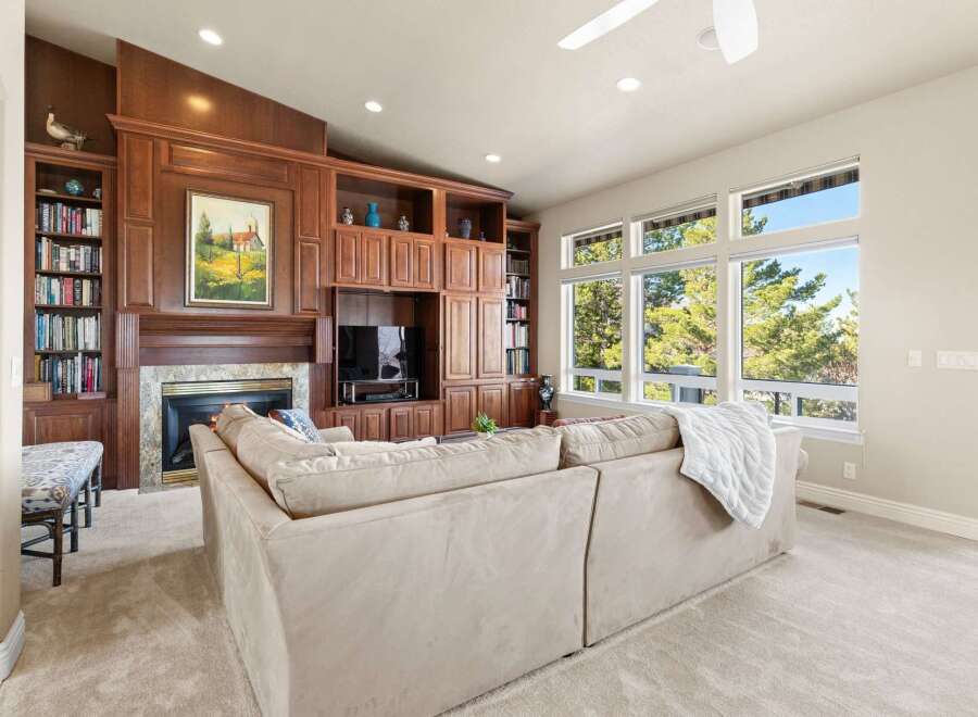 Step into luxury with this stunning living room, featuring a custom built-in entertainment center and a cozy fireplace.