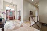 Step into luxury with this stunning entryway! Featuring a grand entrance with a beautiful chandelier, elegant wooden doors, and exquisite flooring.
