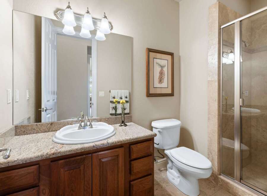 Step into this beautifully designed bathroom, featuring a granite countertop and rich wooden cabinetry that exudes warmth and sophistication.
