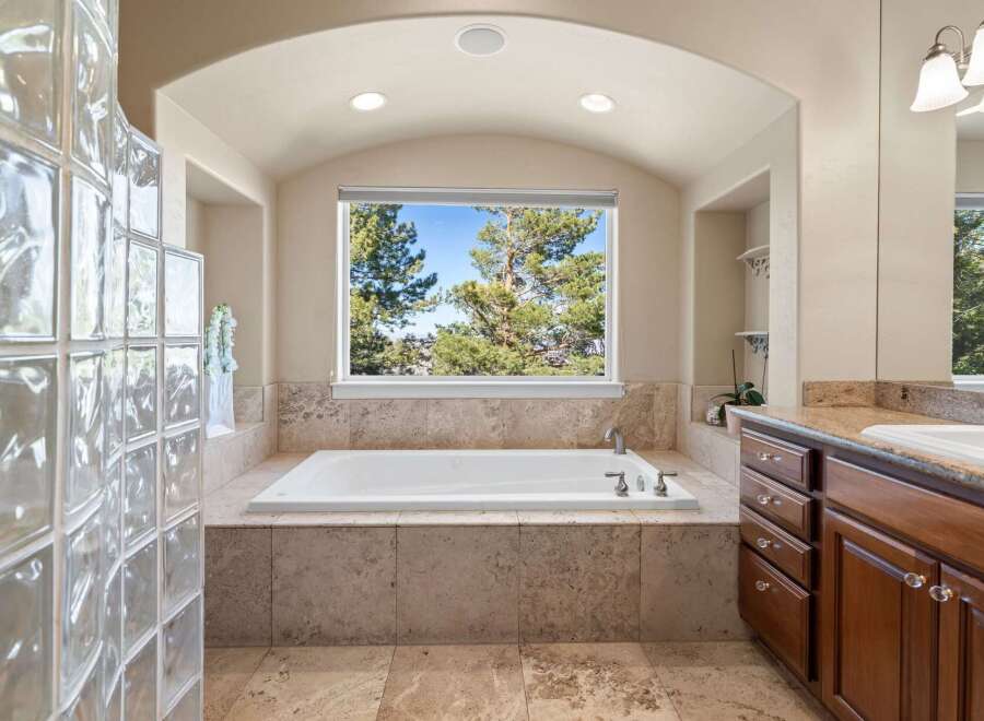 Indulge in the luxury of this stunning bathroom, featuring a spacious soaking tub and elegant stone accents.