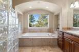 Indulge in the luxury of this stunning bathroom, featuring a spacious soaking tub and elegant stone accents.