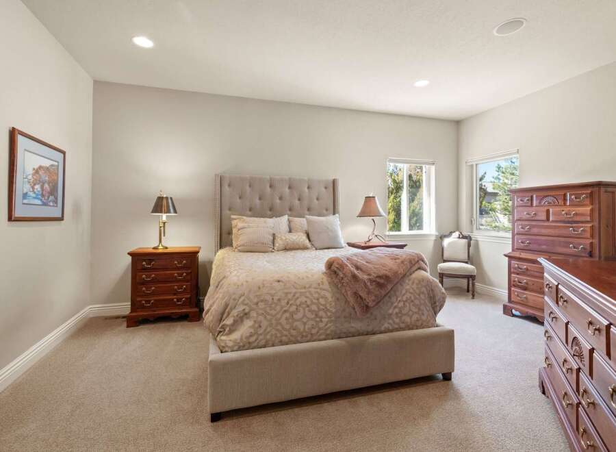 This elegant bedroom showcases a luxurious upholstered bed, complemented by matching nightstands and a stunning dresser.