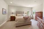 This elegant bedroom showcases a luxurious upholstered bed, complemented by matching nightstands and a stunning dresser.