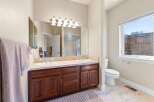 This stunning bathroom features a double vanity with a beautiful countertop and rich, dark wood cabinetry, offering ample storage space.