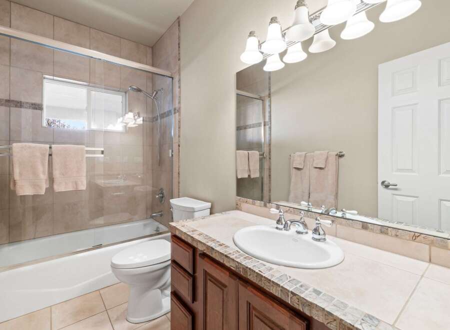 Step into this beautifully designed bathroom, featuring a modern shower with glass doors and elegant tile work.