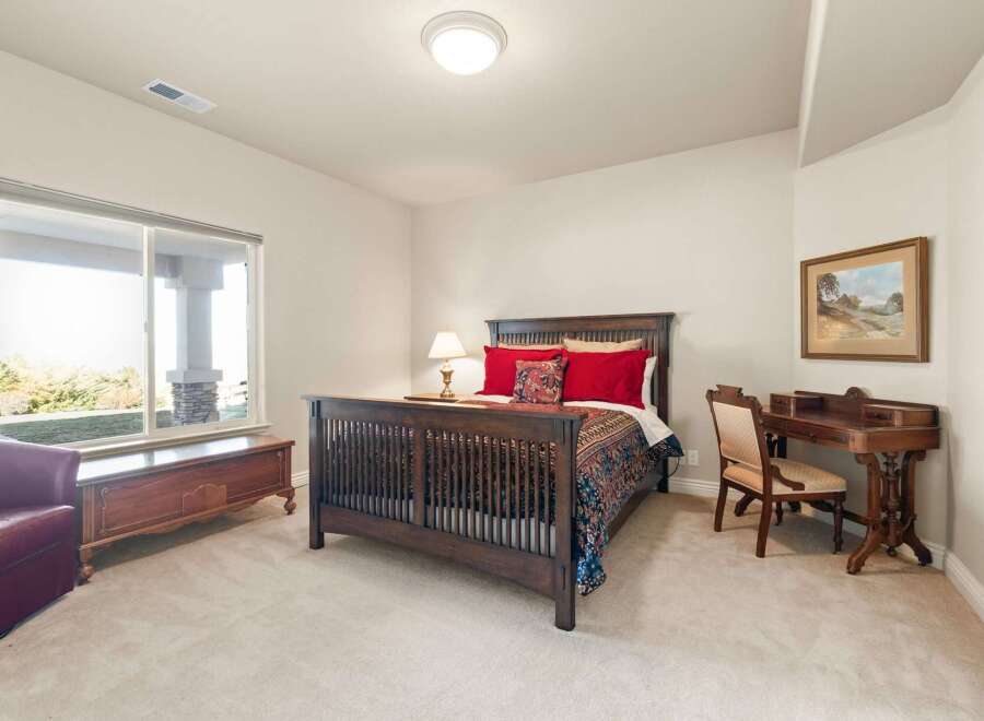 This inviting bedroom features a cozy atmosphere with a comfortable bed and a stylish desk.