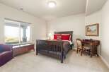This inviting bedroom features a cozy atmosphere with a comfortable bed and a stylish desk.