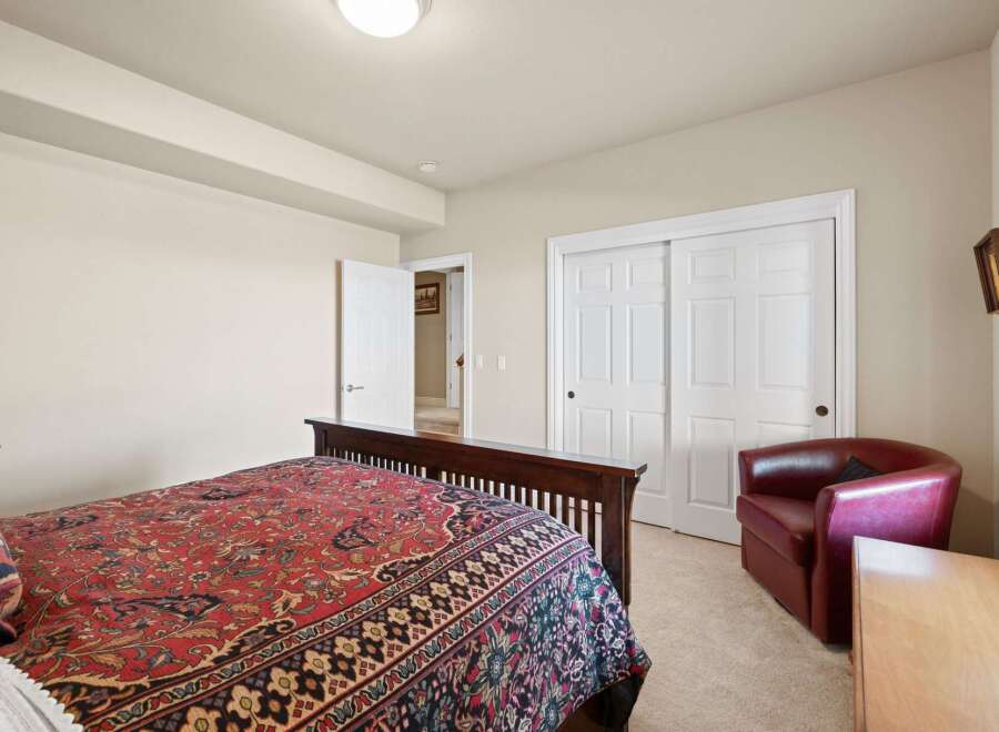 This inviting bedroom features a comfortable bed with a vibrant patterned comforter, creating a warm and welcoming atmosphere.