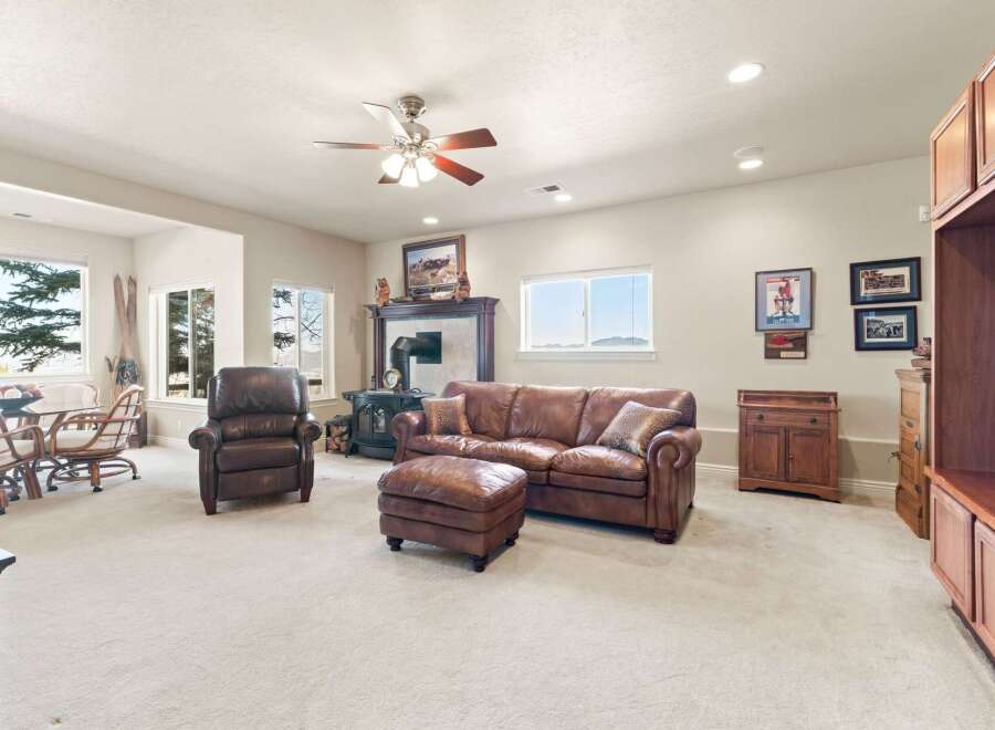 Step into luxury with this stunning living room, featuring a cozy leather sofa, armchair, and ottoman set.