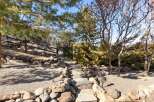 Discover the tranquility of this beautifully landscaped property, featuring a charming stone pathway leading to a gated entrance.