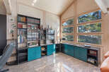 This spacious living area features a stunning floor-to-ceiling bookshelf and bar, perfect for entertaining guests.