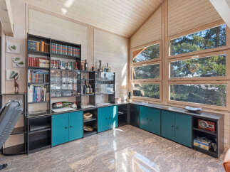 This spacious living area features a stunning floor-to-ceiling bookshelf and bar, perfect for entertaining guests.
